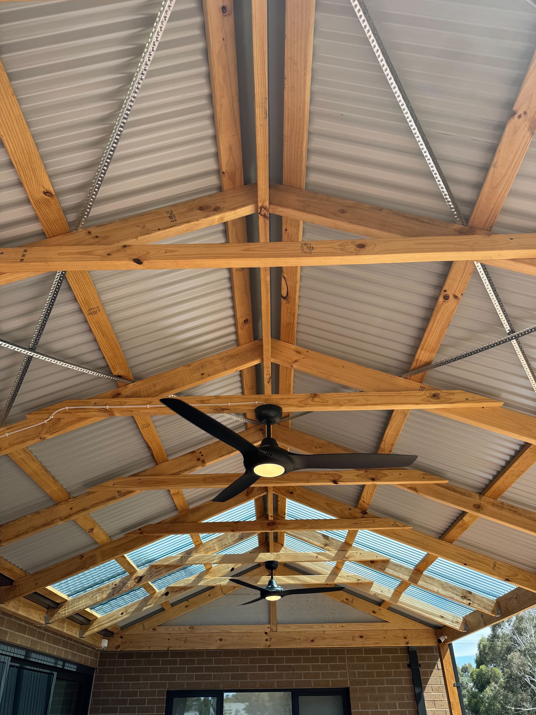 Alfresco ceiling fans and lighting installed under exposed timber trusses
